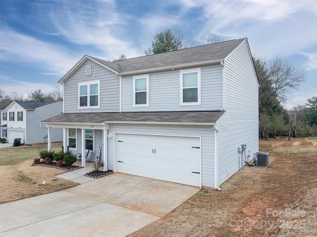 traditional-style house with a garage, a porch, driveway, and central AC unit