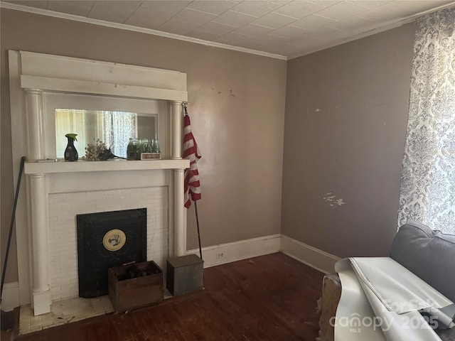 living room with baseboards, a fireplace, ornamental molding, and wood finished floors