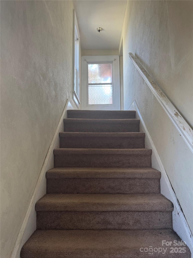 stairs featuring a textured wall