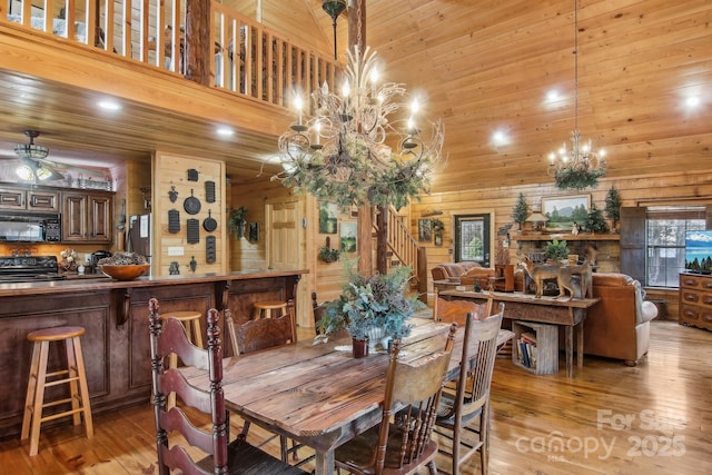 dining room featuring light wood-type flooring, wooden ceiling, and a towering ceiling