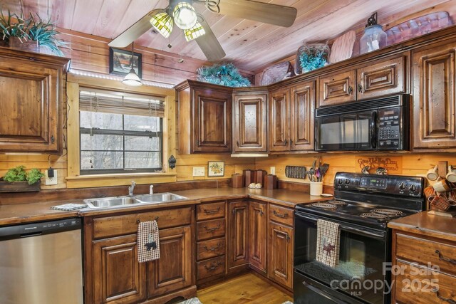 kitchen with light wood finished floors, wood ceiling, ceiling fan, black appliances, and a sink