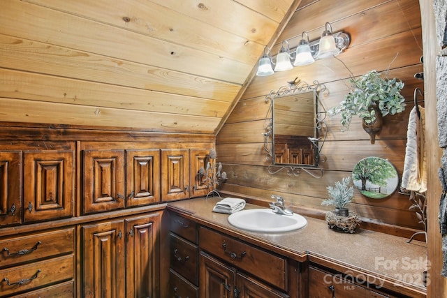 bathroom with lofted ceiling, wooden ceiling, vanity, and wood walls