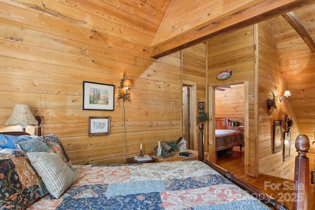 bedroom with lofted ceiling, wood walls, and wood finished floors