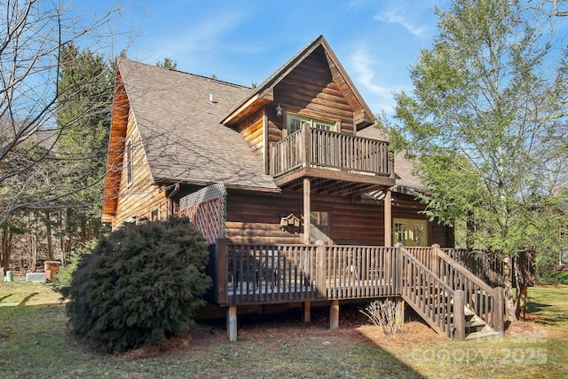 rear view of property featuring a balcony, a wooden deck, and roof with shingles