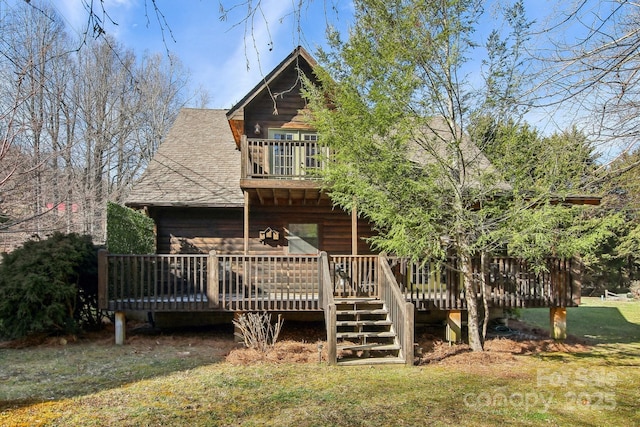 back of house featuring a shingled roof and a balcony