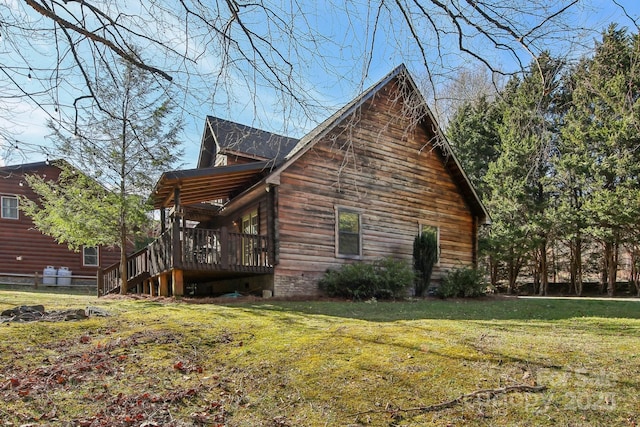 view of side of home featuring a yard, a wooden deck, and stairs