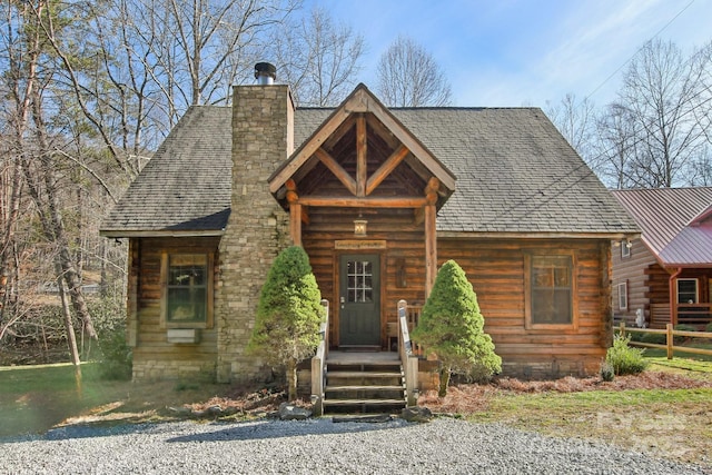 log-style house with a chimney and roof with shingles