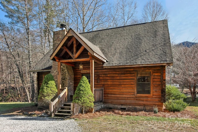 log cabin featuring crawl space, a shingled roof, and a chimney