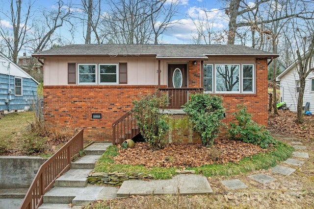 view of front of property with crawl space, brick siding, and board and batten siding