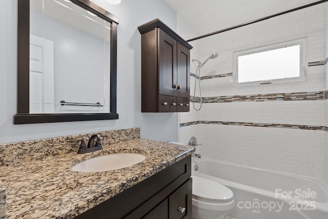 bathroom with tub / shower combination, toilet, and vanity