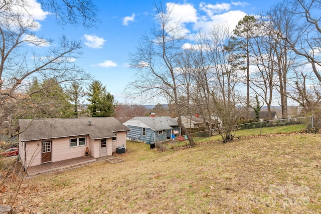 view of yard featuring central AC unit, a deck, and fence