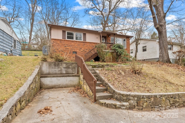 single story home with crawl space, brick siding, concrete driveway, and stairs