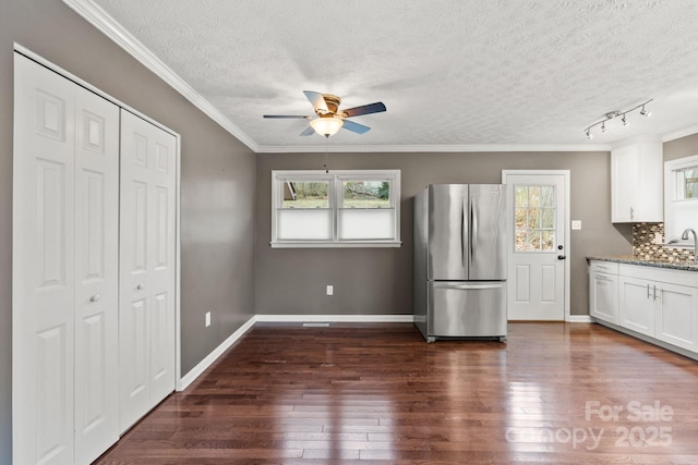 kitchen featuring tasteful backsplash, dark wood-style floors, white cabinets, and freestanding refrigerator