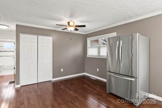 unfurnished bedroom with dark wood-style floors, multiple windows, crown molding, and freestanding refrigerator