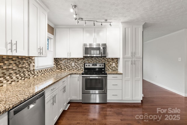 kitchen with decorative backsplash, dark wood-type flooring, appliances with stainless steel finishes, white cabinetry, and crown molding