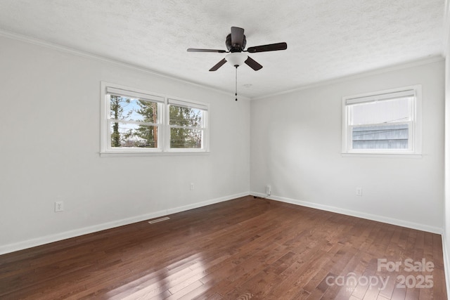 spare room featuring crown molding, dark wood-style floors, baseboards, and a textured ceiling