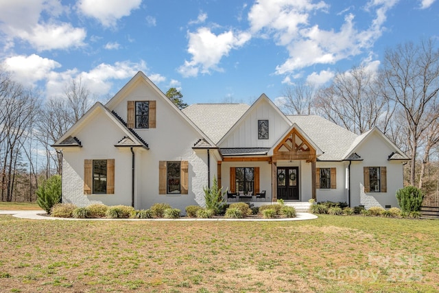 modern farmhouse style home with board and batten siding, roof with shingles, a porch, and a front lawn