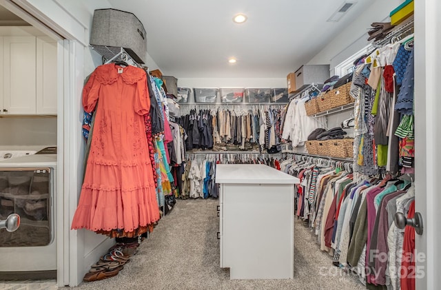 walk in closet with washer / dryer, visible vents, and light carpet