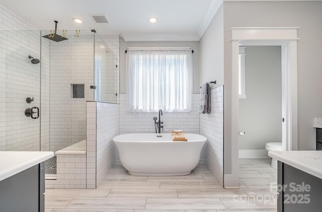 bathroom featuring tiled shower, a soaking tub, vanity, and visible vents