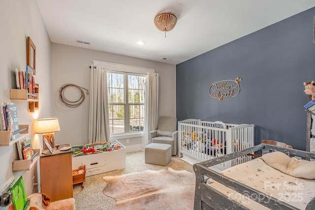 carpeted bedroom with a crib and visible vents