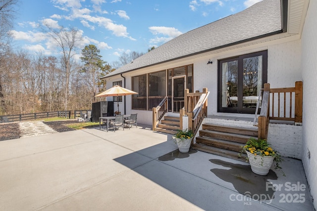 exterior space with a patio area, a shingled roof, fence, and outdoor dining area