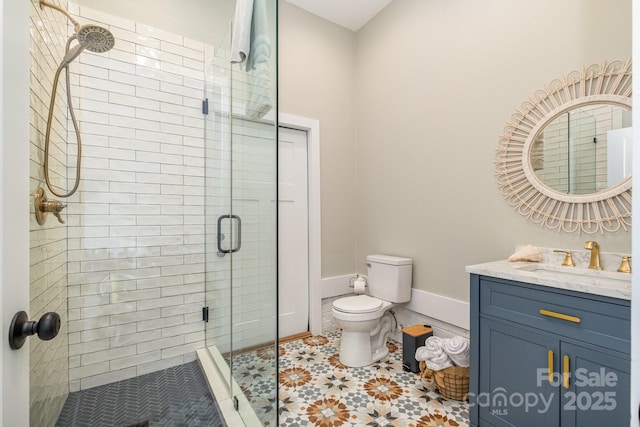 full bath featuring toilet, a shower stall, baseboards, and vanity