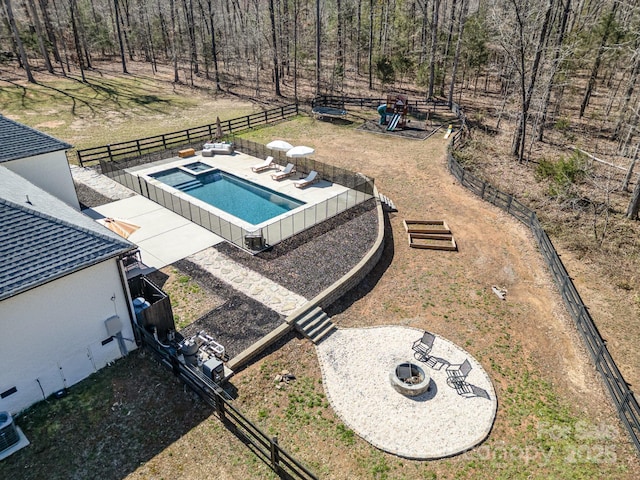 view of swimming pool with a patio, a fenced backyard, a fire pit, a pool with connected hot tub, and a yard