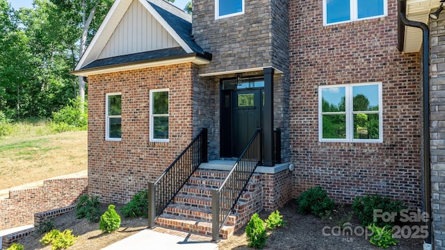 entrance to property featuring board and batten siding and brick siding