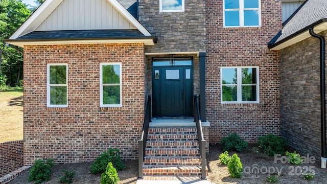 doorway to property featuring brick siding and board and batten siding