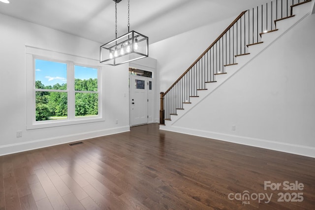 entryway featuring dark wood-style flooring, visible vents, baseboards, and stairs