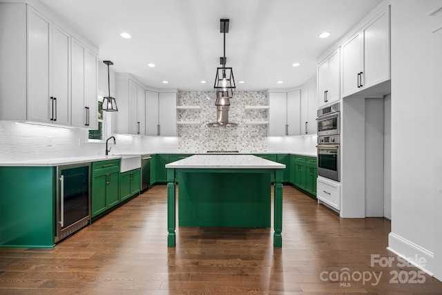 kitchen featuring dark wood finished floors, open shelves, a sink, beverage cooler, and green cabinetry