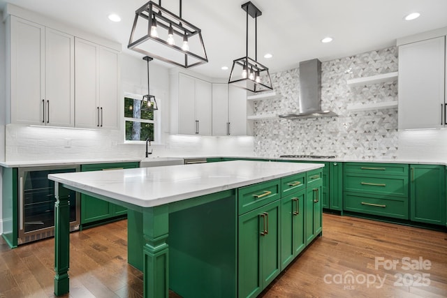 kitchen with green cabinetry, wall chimney exhaust hood, and open shelves