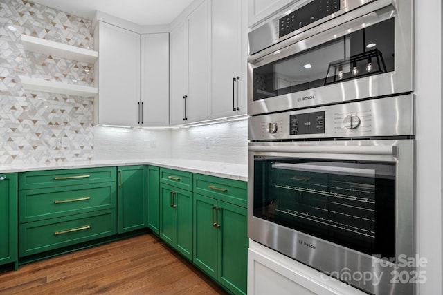 kitchen featuring decorative backsplash, green cabinets, dark wood finished floors, and oven