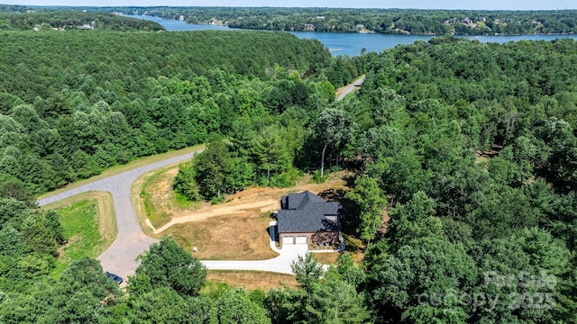 drone / aerial view with a forest view and a water view