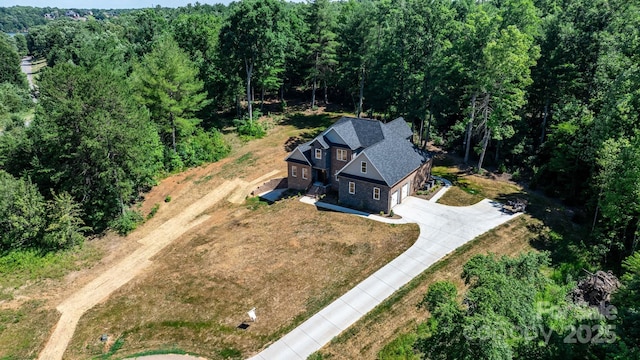 drone / aerial view featuring a wooded view