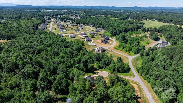 birds eye view of property with a mountain view and a wooded view