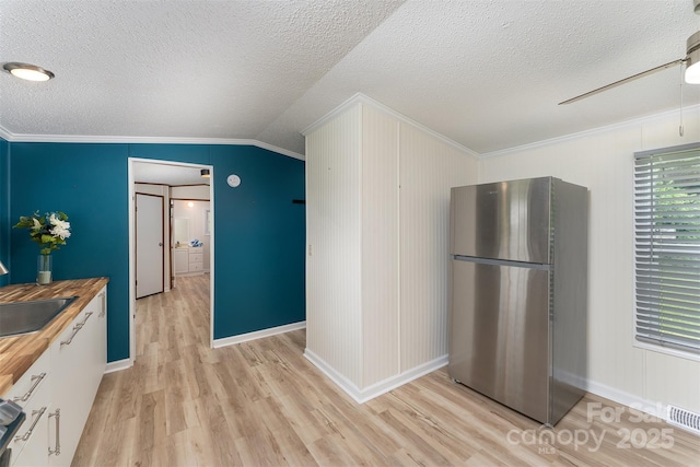 843 Deep Gap Loop Rd, Flat Rock, NC 28731 - kitchen with freestanding refrigerator, wood counters, crown molding, light wood-style floors, and a textured ceiling