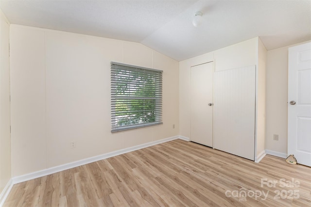 843 Deep Gap Loop Rd, Flat Rock, NC 28731 - unfurnished bedroom featuring light wood-type flooring, lofted ceiling, and baseboards