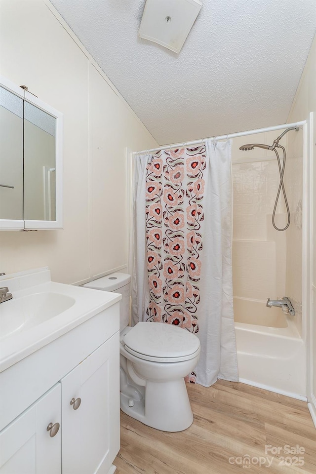 843 Deep Gap Loop Rd, Flat Rock, NC 28731 - bathroom featuring wood finished floors, vanity, shower / bath combination with curtain, toilet, and a textured ceiling