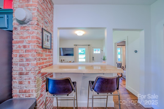 124 Dodge St, Asheville, NC 28803 - kitchen with wood finished floors, baseboards, and a kitchen breakfast bar