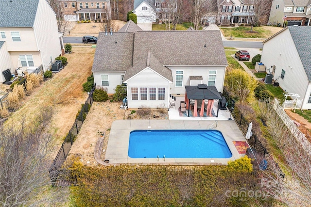 rear view of property with fence, a gazebo, a residential view, a fenced in pool, and a patio area