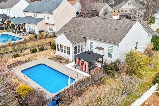 view of pool with a gazebo, a fenced backyard, a residential view, and a patio area