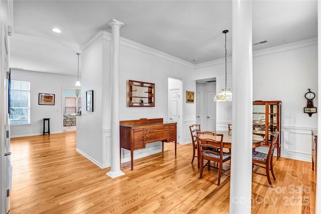 dining area with light wood-style flooring, decorative columns, visible vents, and ornamental molding