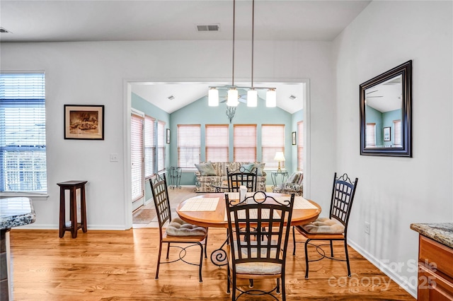 dining area featuring vaulted ceiling, baseboards, visible vents, and light wood-type flooring