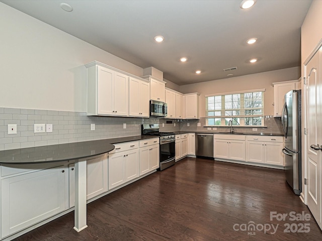 kitchen featuring dark countertops, white cabinets, and stainless steel appliances