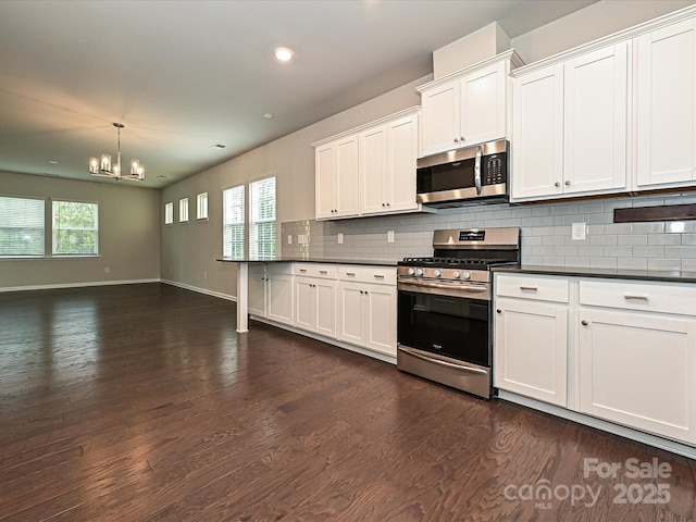 kitchen with appliances with stainless steel finishes, dark wood-type flooring, dark countertops, and decorative backsplash