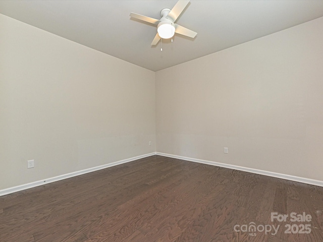 spare room with dark wood-style floors, baseboards, and a ceiling fan