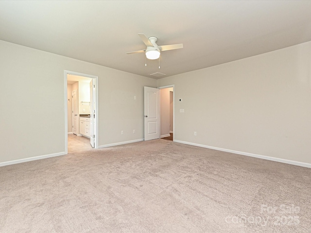 spare room featuring baseboards, a ceiling fan, and light colored carpet