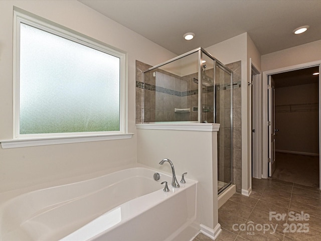 full bathroom featuring a walk in closet, a garden tub, recessed lighting, a stall shower, and tile patterned flooring