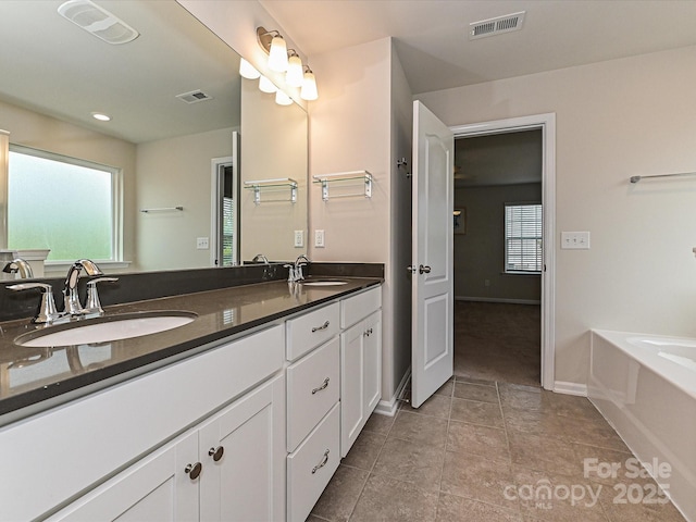 bathroom with tile patterned flooring, visible vents, a sink, and double vanity